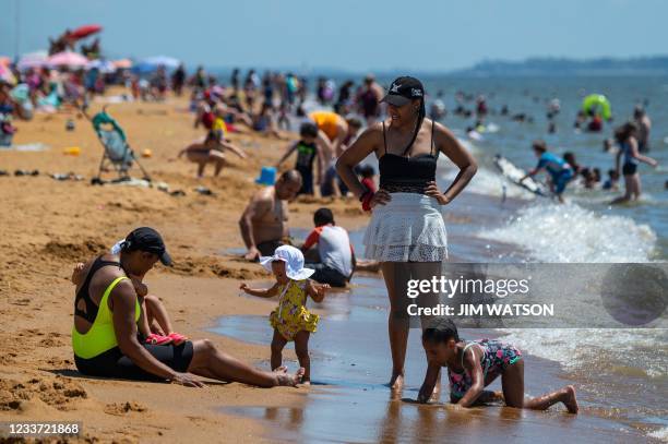 People play on the beach and in the Chesapeake Bay as they try to escape the heat at Sandy Point State Park in Annapolis, Maryland on June 29, 2021....