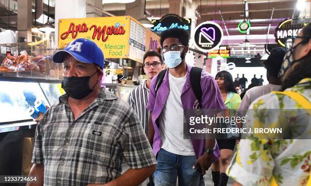 Masked and unmasked people make their way through Grand Central Market in Los Angeles, California on June 29, 2021 as World Health Organization urges...