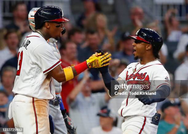 Ozzie Albies reacts with Ronald Acuna Jr. #13 of the Atlanta Braves after hitting a three-run home run in the fifth inning of an MLB game against the...