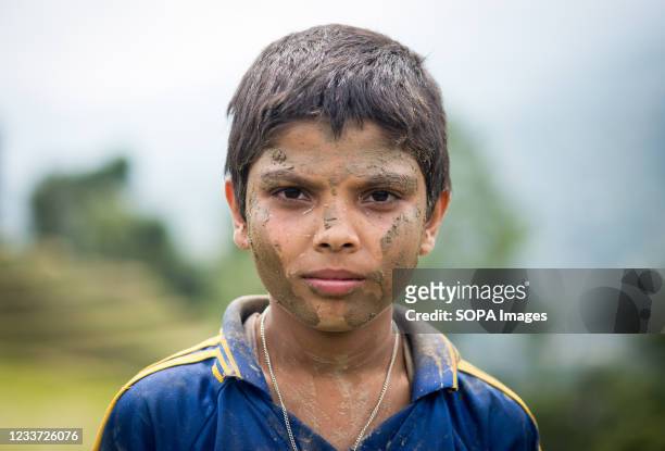 Kid's face covered with mud in a rice paddy field during the National Paddy Day. Nepalese farmers celebrate National Paddy Day which marks the start...