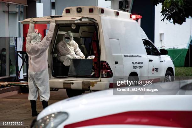 Health workers wearing Personal Protective Equipment are seen in an ambulance after delivering covid-19 patients inside the Wisma Atlet Covid-19...