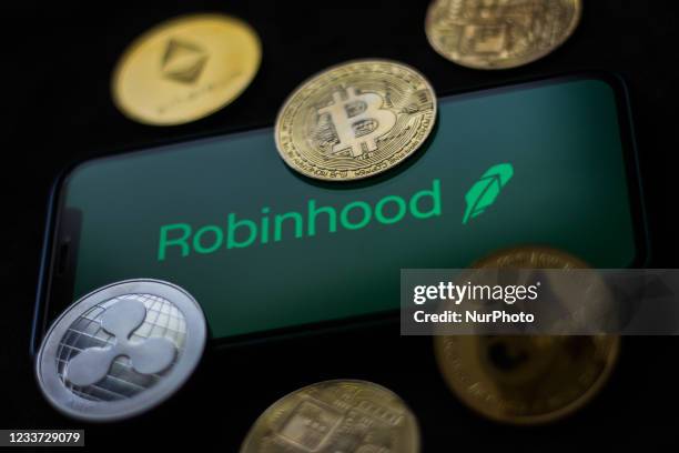 Robinhood logo displayed on a phone screen and representation of cryptocurrencies are seen in this illustration photo taken in Krakow, Poland on June...