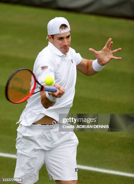 Player John Isner returns against Japan's Yoshihito Nishioka during their men's singles first round match on the third day of the 2021 Wimbledon...