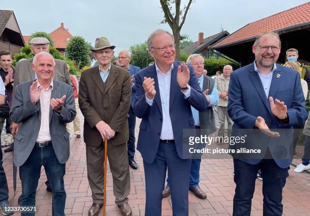 June 2021, Lower Saxony, Saterland: Lower Saxony's Minister President Stephan Weil stands clapping next to the mayor of the municipality of Saterland...