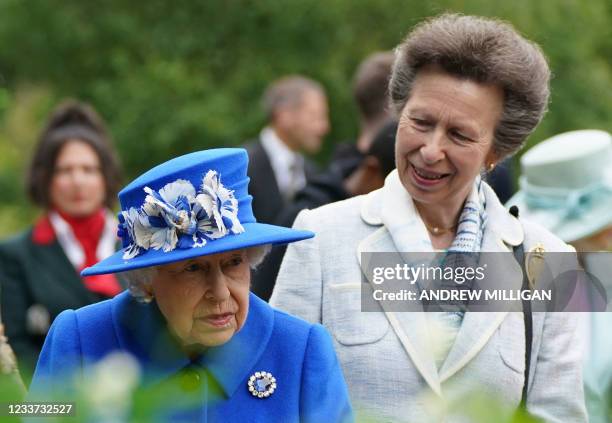 Britain's Princess Anne, Princess Royal speaks to Britain's Queen Elizabeth II during a visit to The Children's Wood Project in Glasgow on June 30 as...