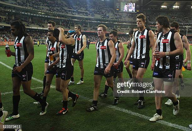 Magpies players walk from the ground after they were defeated by the Cats round 24 AFL match between the Collingwood Magpies and the Geelong Cats at...