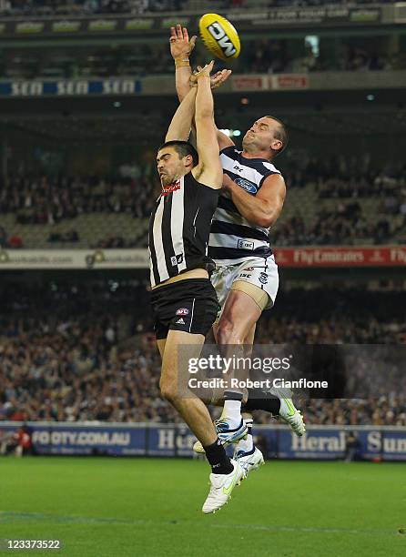 Chris Dawes of the Magpies is challenged by Josh Hunt of the Cats during the round 24 AFL match between the Collingwood Magpies and the Geelong Cats...