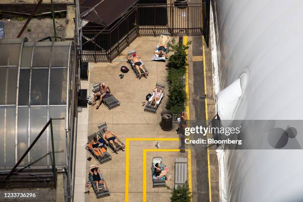 Sunbathers on a roof during a heatwave in New York, U.S., on Wednesday, June 30, 2021. Temperatures in New York and the Northeast will soar again...