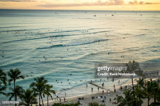 The sun sets off of Waikiki Beach on the Hawaiian island of Oahu on Saturday, June 26, 2021 in Honolulu, HI.