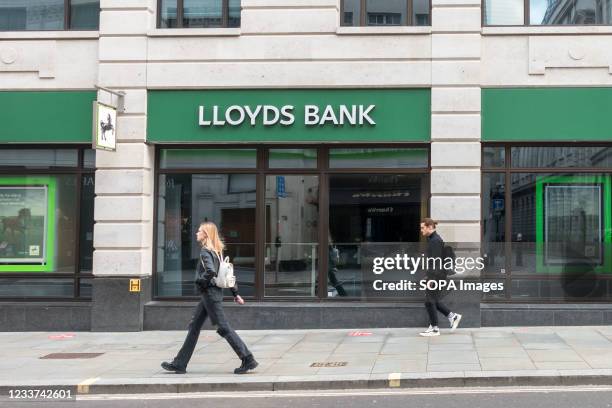 People walk past a Lloyds Bank branch in London.