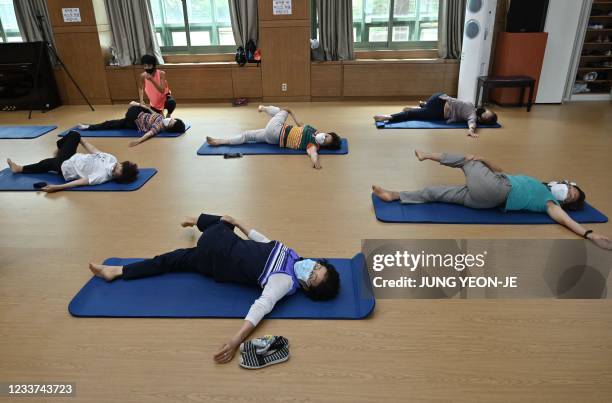 Elderly women wearing face masks attend a yoga class re-opened for the first time since the Covid-19 coronavirus pandemic at Seodaemun Senior Welfare...