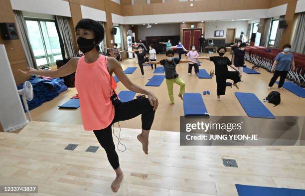 Elderly women wearing face masks attend a yoga class re-opened for the first time since the Covid-19 coronavirus pandemic at Seodaemun Senior Welfare...