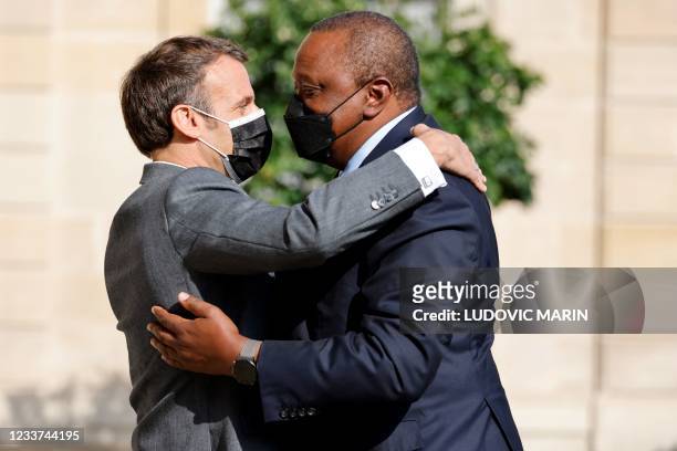 French President Emmanuel Macron welcomes Kenya's President Uhuru Kenyatta before their meeting at the Elysee presiential Palace in Paris on July 1,...