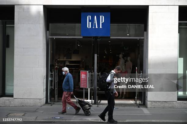 Pedestrians walk past a GAP store in central London on July 1, 2021. - US apparel company Gap will close its 81 stores in Britain and Ireland by...