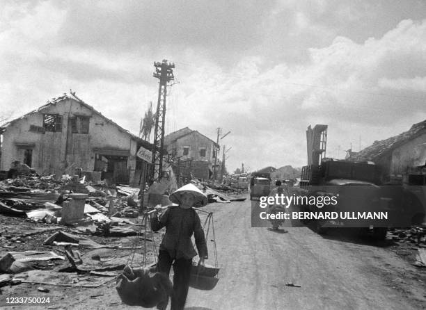 Vietnamese woman walks past the rubble of destroyed houses after bombardment by South Vietnamese air forces and artillery in the village of Dak Do on...