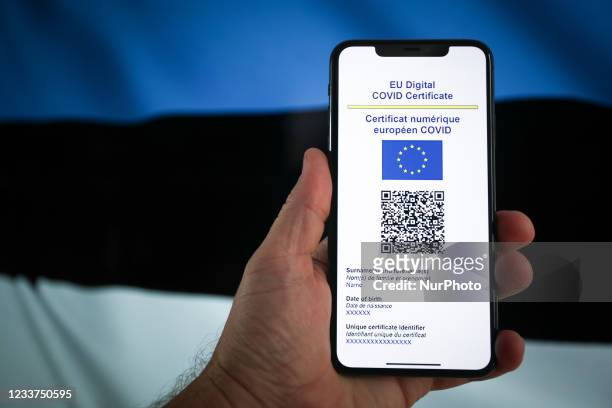 An EU COVID certificate is seen on a mobile device in with a Estonian flag in the background in this photo illustartion in Warsaw, Poland on July 1,...