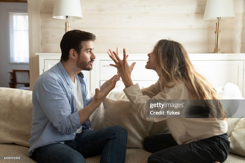 Emotional annoyed stressed couple arguing at home.