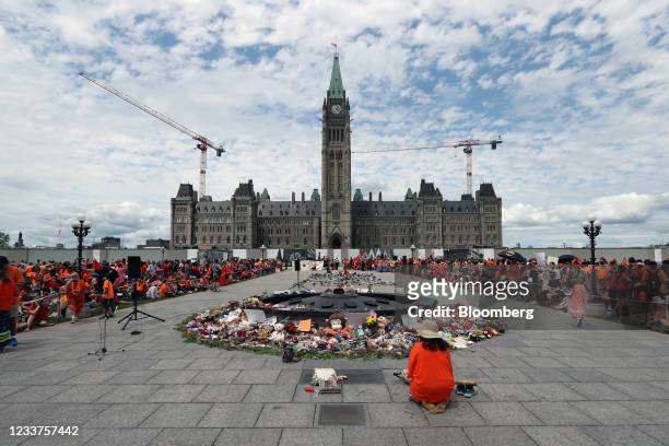 Demonstrators wearing orange in solidarity with survivors of residential schools gather in front of Parliament Hill on Canada Day in Ottawa, Ontario,...