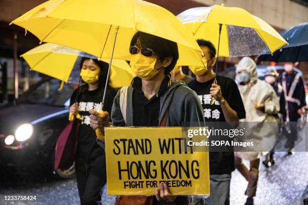 Protester holding a 'Stand with Hong Kong' placard and yellow umbrella, during the demonstration. 1st of July marks the 100th anniversary of the...