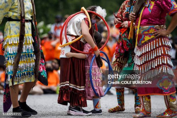 Hoop dancer Emilee Ann, left, hugs her friend Ayiana Myran as they wait to perform alongside other dancers at Toronto City Hall during the Every...