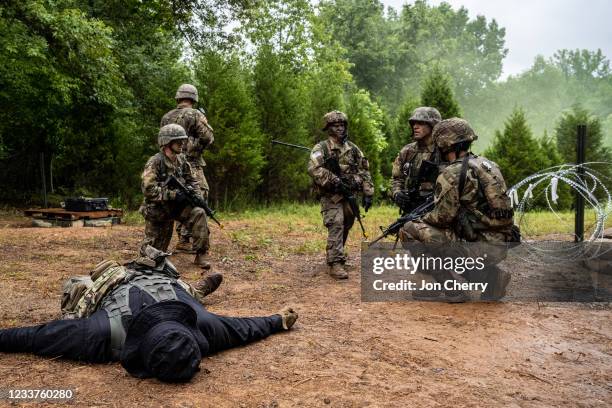 Cadets of the 3rd Regiment secure their objective while a downed member of the opposing force lies nearby in Training Area 9 during Army ROTC Cadet...