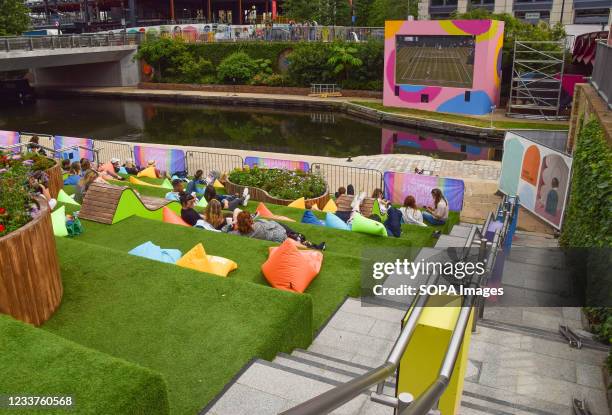 People are seen watching the Wimbledon tennis championship on an outdoor screen at Granary Square in King's Cross, London. Summer Love, a free...