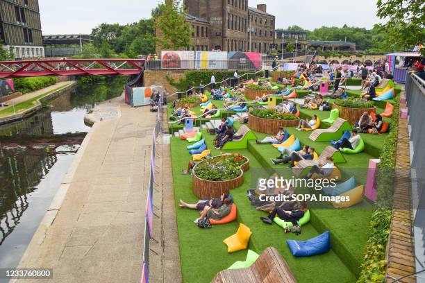 People are seen watching the Wimbledon tennis championship on an outdoor screen at Granary Square in King's Cross, London. Summer Love, a free...