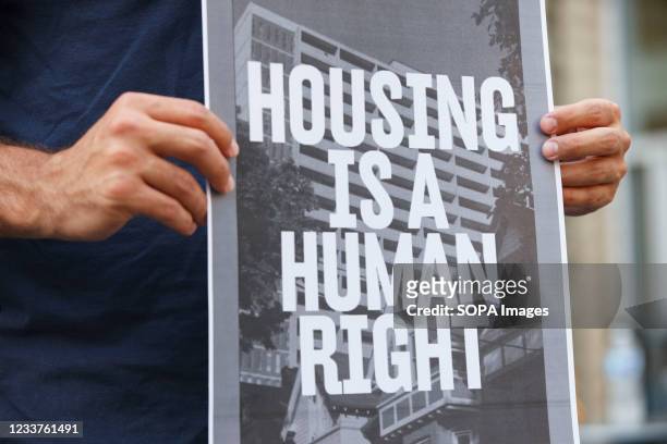 Man holds a placard that says Housing is a human right during rally for housing rights in front of the Greater Columbus Convention Center. Columbus...