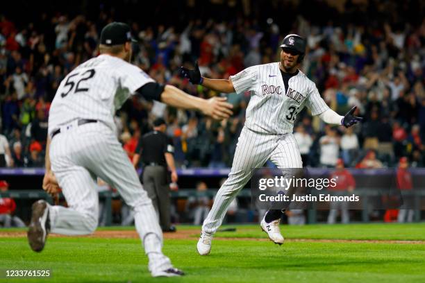 Elias Diaz of the Colorado Rockies celebrates his walk-off three-run home run with Daniel Bard of the Colorado Rockies during the ninth inning...