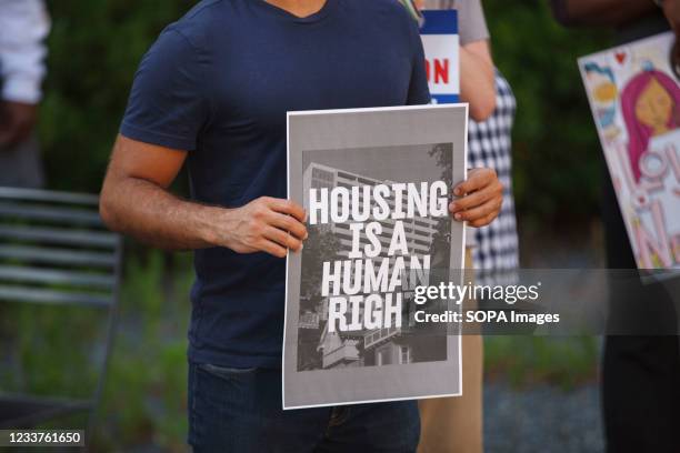 Man holds a placard that says Housing is a human right during rally for housing rights in front of the Greater Columbus Convention Center with other...