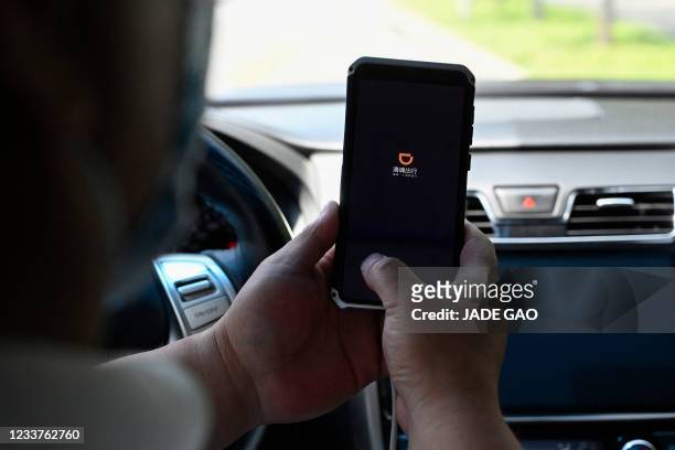 Driver opens the Didi Chuxing ride-hailing app on his smartphone in Beijing on July 2, 2021.