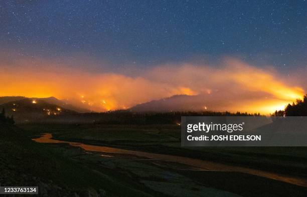 In this long exposure photograph, flames surround a drought-stricken Shasta Lake during the "Salt fire" in Lakehead, California early on July 2 as...