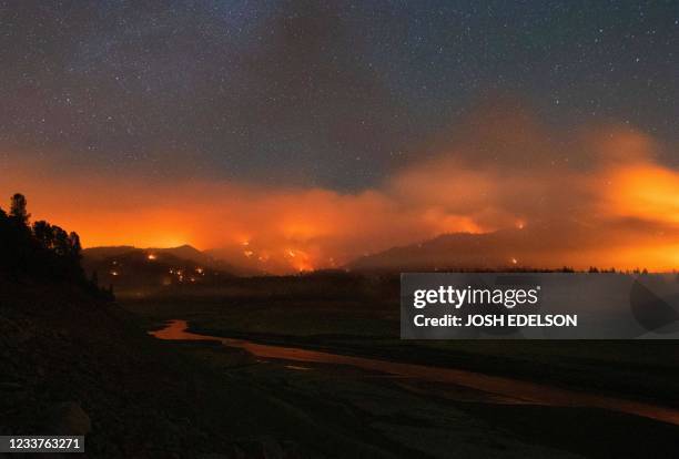 In this long exposure photograph, flames surround a drought-stricken Shasta Lake during the "Salt fire" in Lakehead, California early on July 2 as...