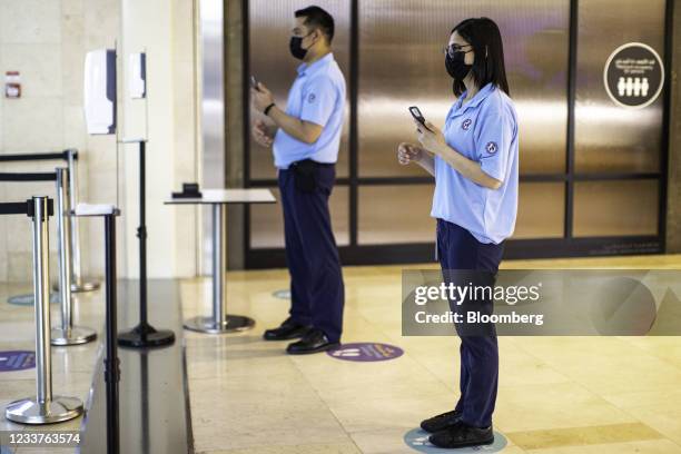 Safety stewards wait to scan shoppers with smartphones enabled with Covid-19 detection software, developed by EDE Research Institute, at the entrance...