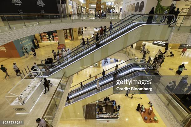 Visitors ride escalators between shopping floors inside Yas Mall, operated by Aldar Properties PJSC, in Abu Dhabi, United Arab Emirates, on Thursday,...