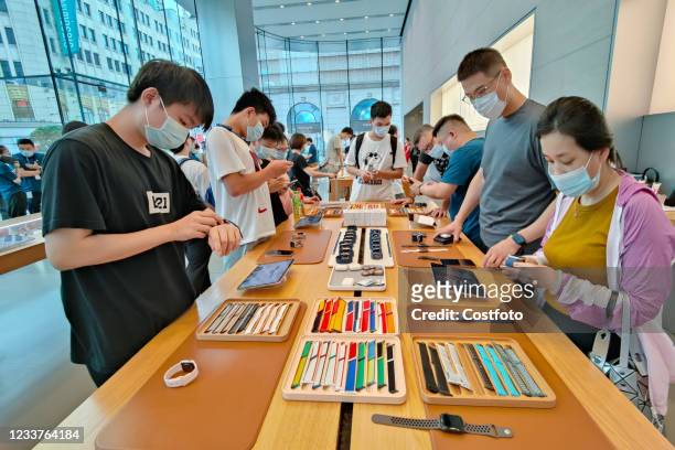 Consumers pick up a trial of Apple Watch Series 6 and Apple Watch Series SE at the Apple Store on Nanjing Road in Shanghai, China, July 2, 2021....
