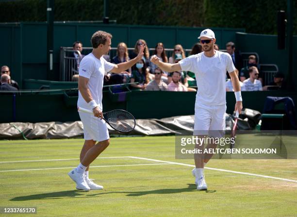 Britain's Jamie Murray and Brazil's Bruno Soares celebrates winning a point against US player Nicholas Monroe and Canada's Vasek Pospisil in their...