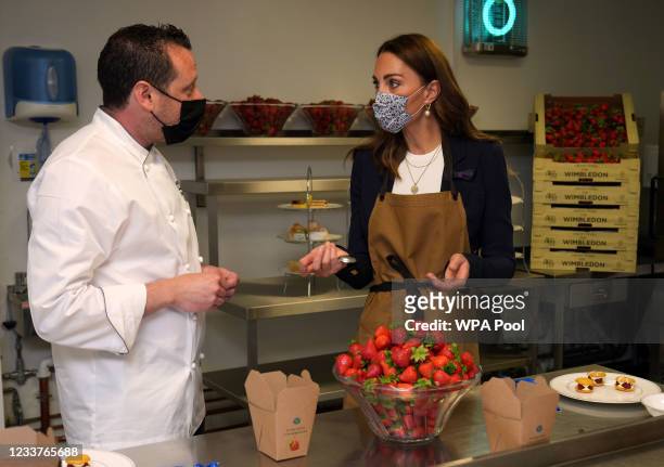 Catherine, Duchess of Cambridge helps to prepare strawberry desserts in the kitchens with the All England Lawn Tennis Club Executive Chef Adam Fargin...