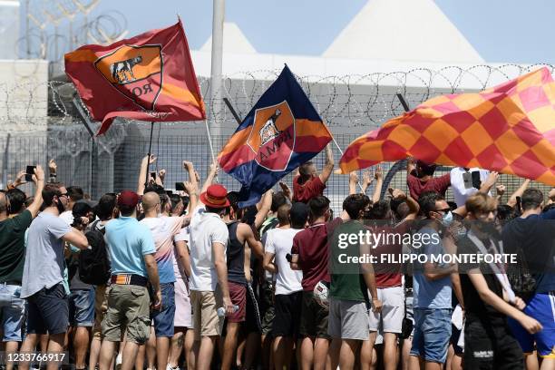 Football fans gather holding AS Roma club flags for the arrival of Portuguese football coach Jose Mourinho at Rome's Ciampino airport on July 2,...