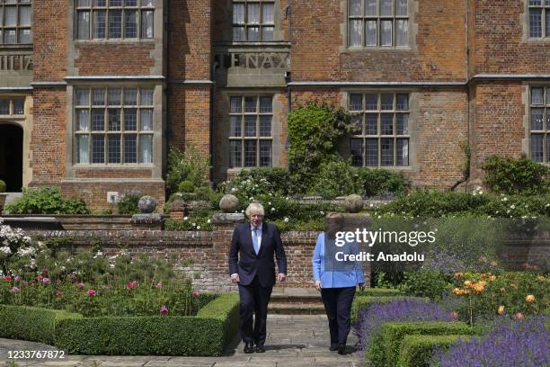 The Prime Minister Boris Johnson walks with the Chancellor of Germany Angela Merkel at the garden of Prime Ministers country residence Chequers in...