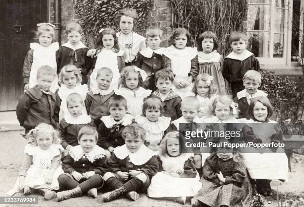 Primary School group photograph, all wearing their Sunday Best clothes, posed with their teacher, in Bromley, Kent, circa 1905.