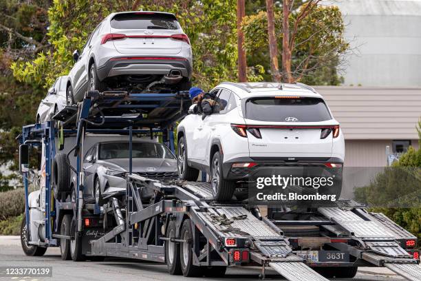 Worker unloads a Hyundai vehicle off of a transporter truck at a car dealership in Richmond, California, U.S., on Thursday, July 1, 2021. The global...