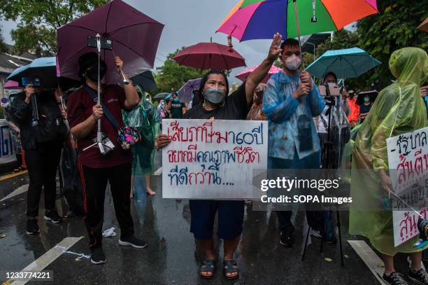 Protester makes the three finger salute while holding a placard that expresses her opinion during the demonstration. The pro-democracy protesters led...