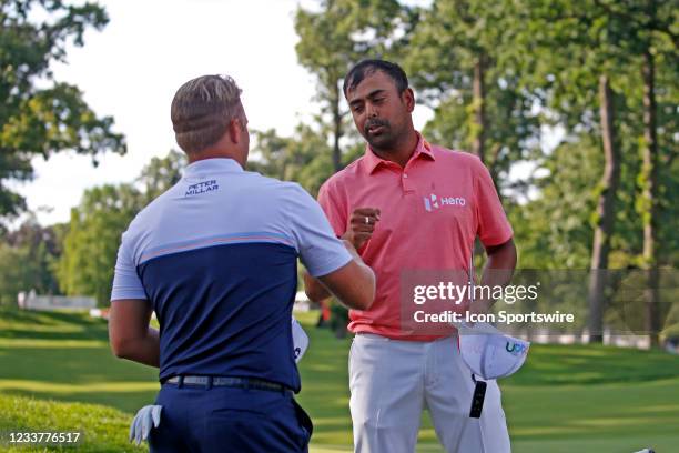 Golfer Tom Lewis congratulated by Anirban Lahiri after finishing on the 9th green as a co leader at 10 under par on July 2, 2021 during the Rocket...