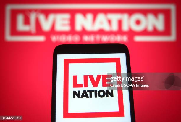 In this photo illustration a Live Nation Entertainment logo is seen on a smartphone and a pc screen.