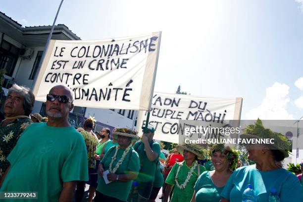 Some Polynesians amongst 2000 hold placards reading "Colonialism is a crime against humanity" and "The DNA of the Maori people is contaminated"...