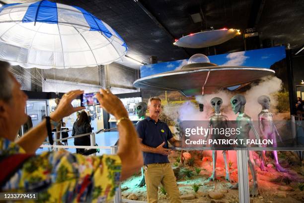 People take pictures of exhibits at the International UFO Museum and Research Center during the UFO Festival on July 2, 2021 in Roswell, New Mexico....