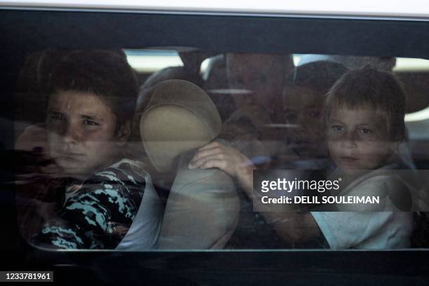 Russian orphans born to parents linked to the Islamic State wait in a bus before Syrian Kurdish authorities hand them over to a Russian delegation...
