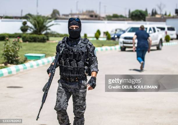 Member of Kurdish securiy forces stands guard as Syrian Kurdish authorities set out to hand over Russian orphans born to parents linked to the...