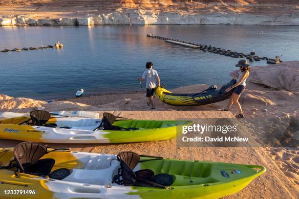 Kayakers climb down the drop-off below the Antelope Point boat launch ramp which was made unusable by record low water levels at Lake Powell as the...